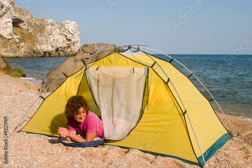Red-haired girl lying in sleeping-bag at seaside
