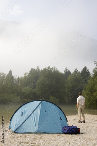 Wanderer steht neben seinem Zelt