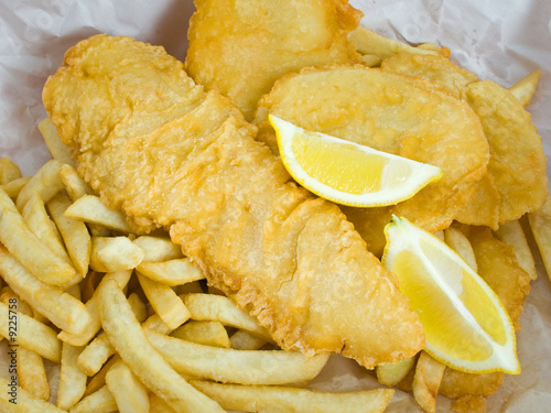 Traditional fish and chips with lemon in paper wrap