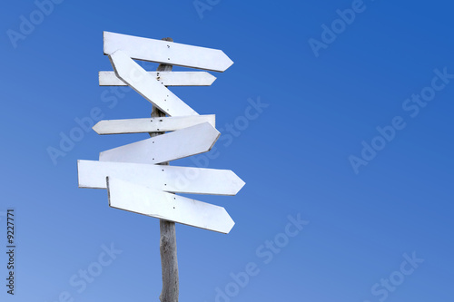An old weathered wooden signpost with blank signs