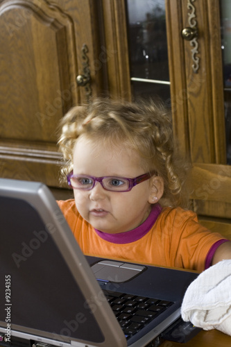 Petite fille travaillant sur un pc portable