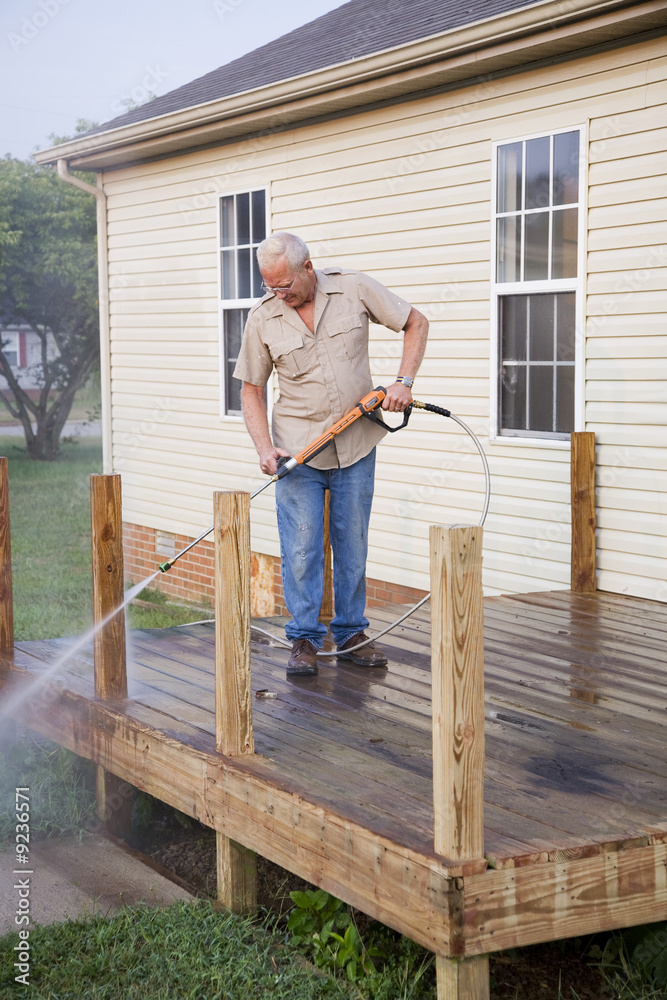 Contractor pressure washing deck , getting home ready to sell