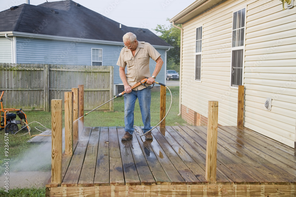 Contractor pressure washing deck , getting home ready to sell