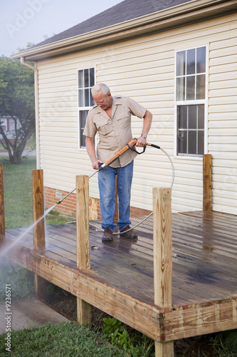 Contractor pressure washing deck , getting home ready to sell © Ernest Prim