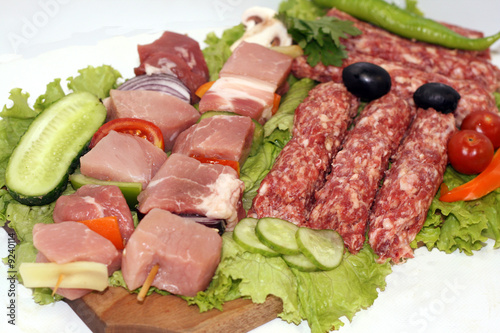 raw meat on wooden plate decorated with vegetables