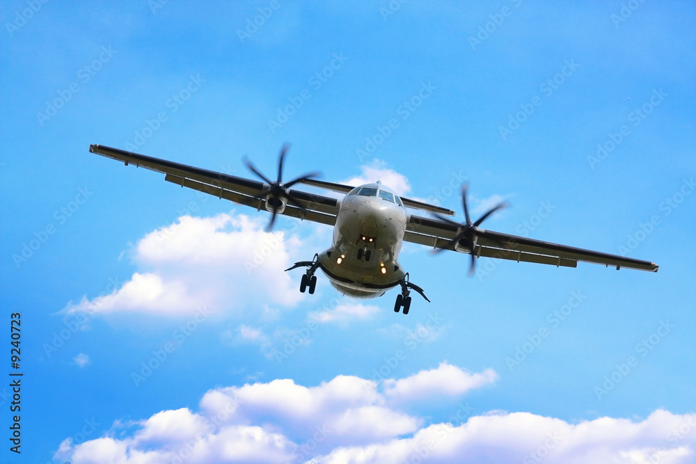 Fototapeta premium propeller airplane landing in cloudy sky