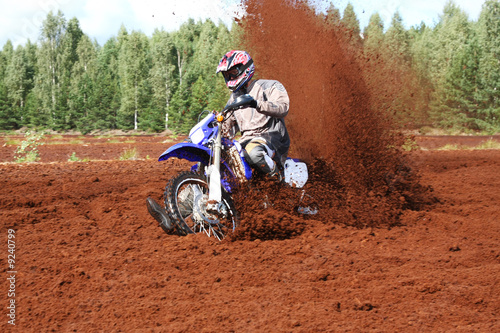 Off-road motorbike extreme cornering in dirt.