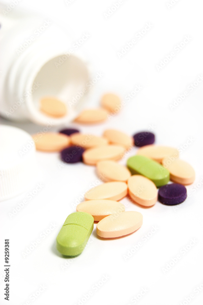 some colourful pills with bottle on a white background some colourful pills with bottle on a white background