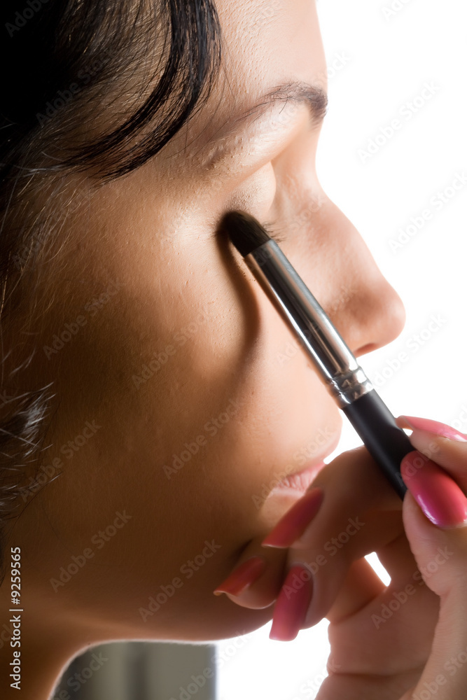 Young attractive woman while making-up