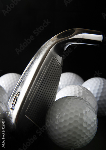 Golf club with golf balls in the black background