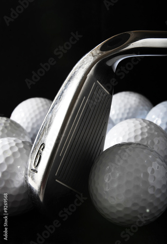 Golf club with golf balls in the black background