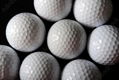 many golf balls on the black background