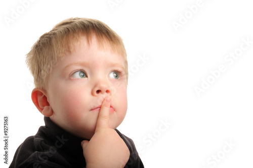 Cute young boy with blonde hair and green eyes looking up