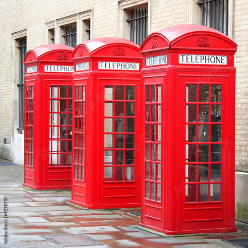 A photography of three old red phone boxes in London