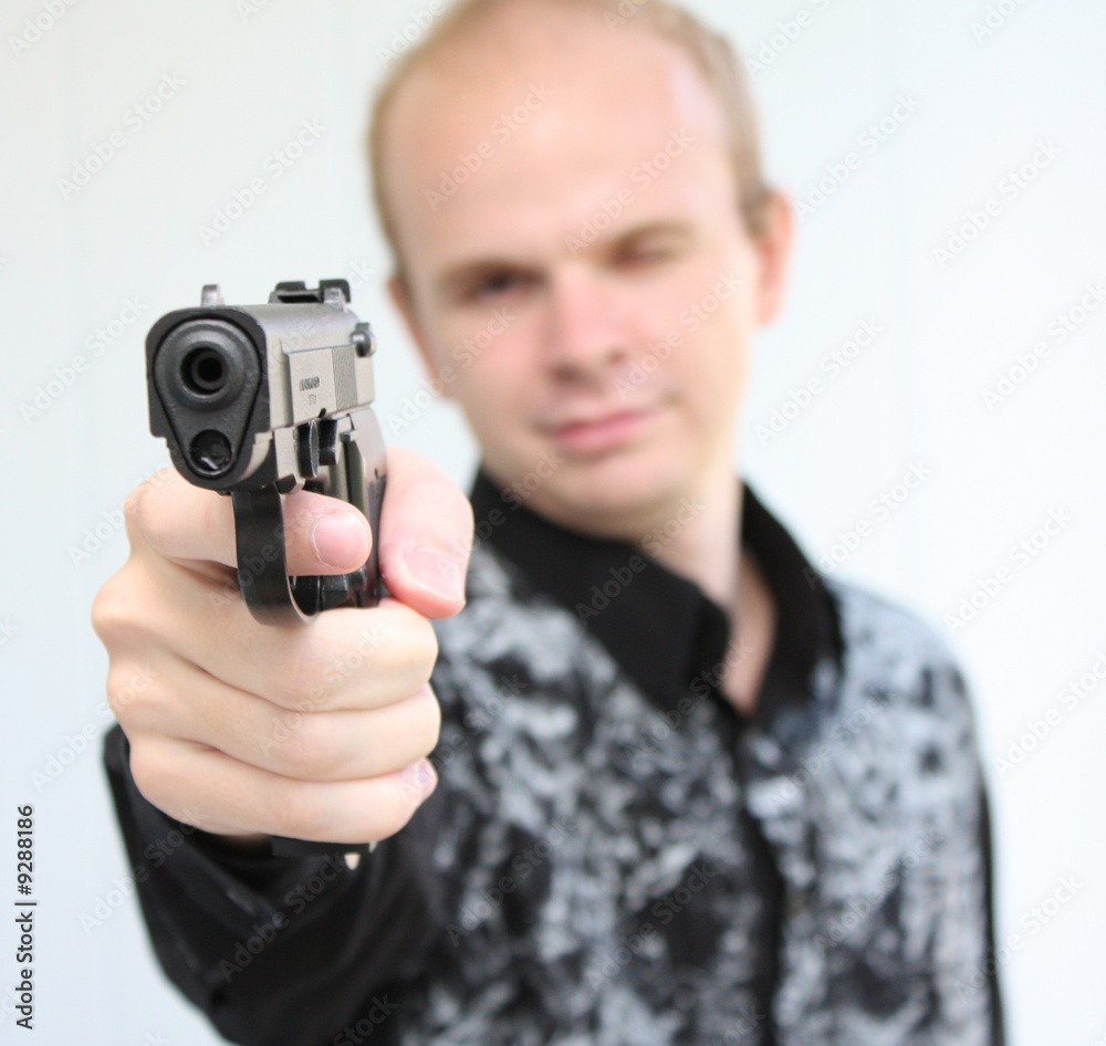 Young man aiming with pistol in hand Young man aiming with pistol in hand