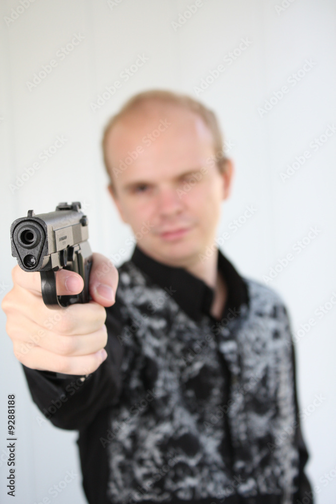 Young man aiming with pistol in hand Young man aiming with pistol in hand