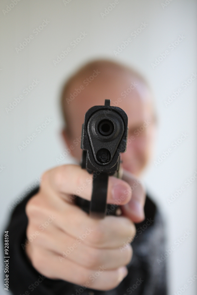 Young man aiming with pistol in hand Young man aiming with pistol in hand