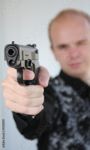 Young man aiming with pistol in hand