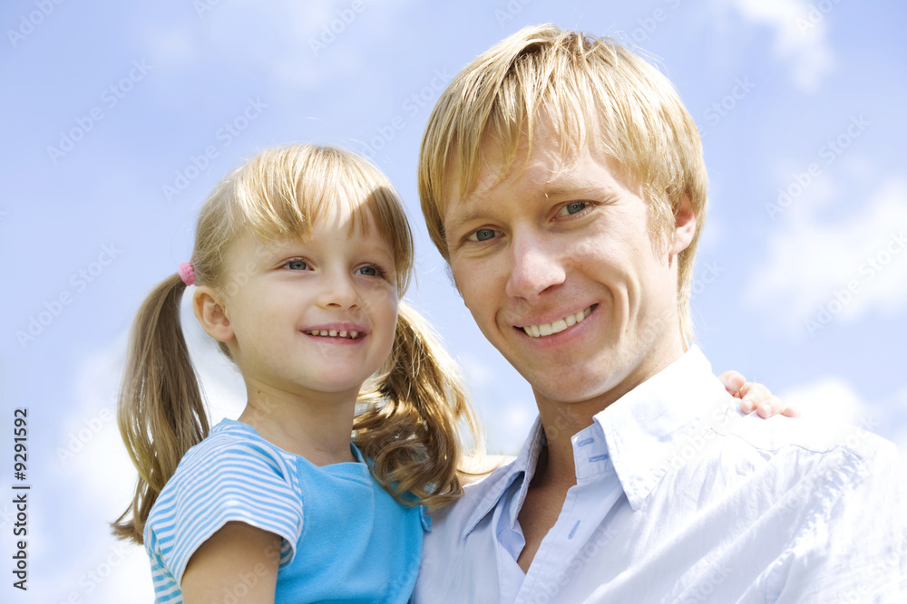 Fototapeta premium Portrait of little girl embracing her father outside