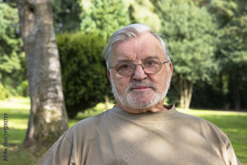 Senior man with glasses in park.