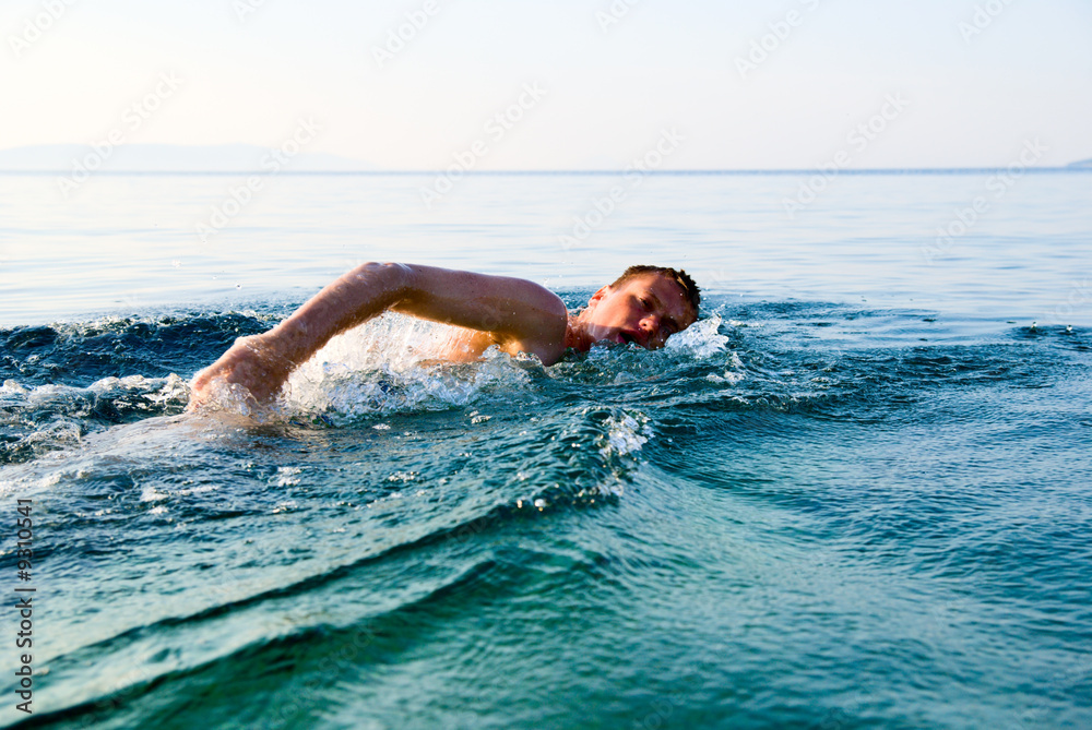 swimming man in clear ocean water