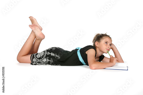 girl writing in journal, looking up and away