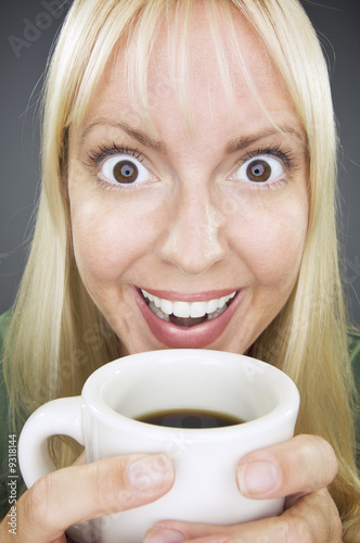 Beautiful Woman Enjoys Her Coffee Against a Grey Background.