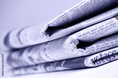 Blue tinted newspapers on light background