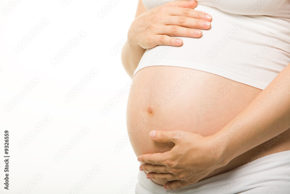 Close-up of pregnant woman’s belly with her hand on it Close-up of pregnant woman’s belly with her hand on it