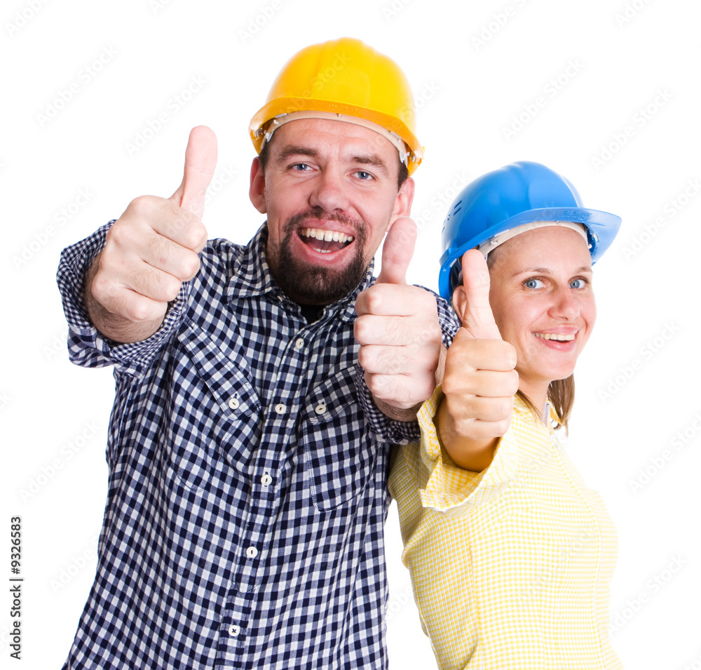 two young people wearing hardhats smiling to camera two young people wearing hardhats smiling to camera