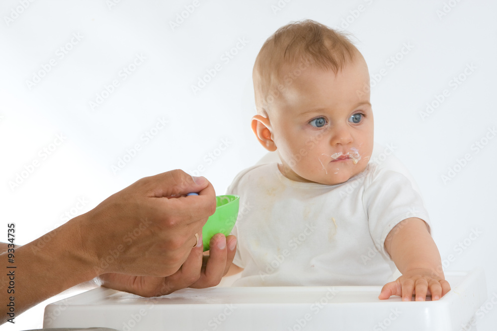 man feeding baby with a spoon, on bright background man feeding baby with a spoon, on bright background