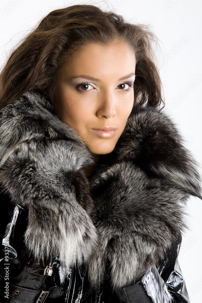 Young dark-haired woman in a leather lacquered jacket with a fur Young dark-haired woman in a leather lacquered jacket with a fur
