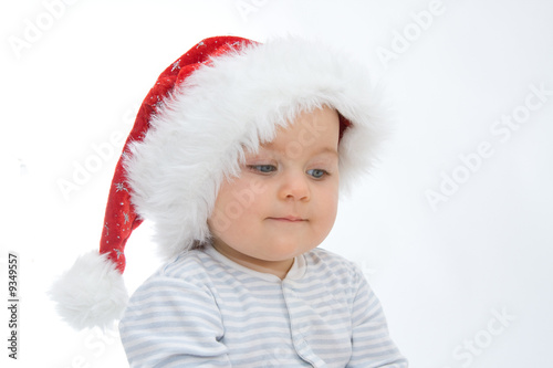 little, cute baby boy wearing Christmas hat, on white