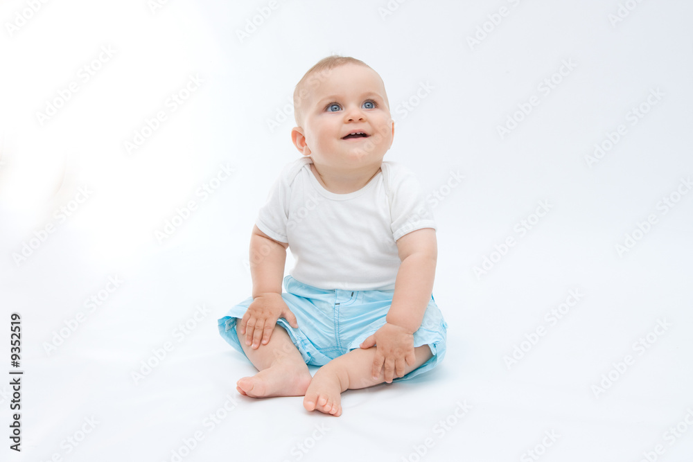 cute laughing baby boy sitting on white background
