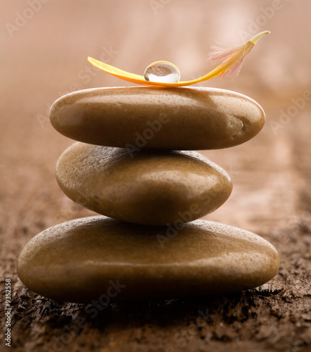 Pile of brown massage stones on wooden background