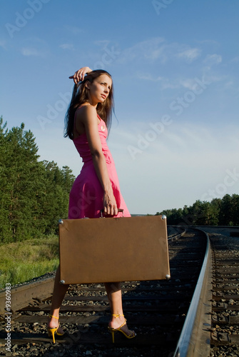 The young woman walks by rail photo