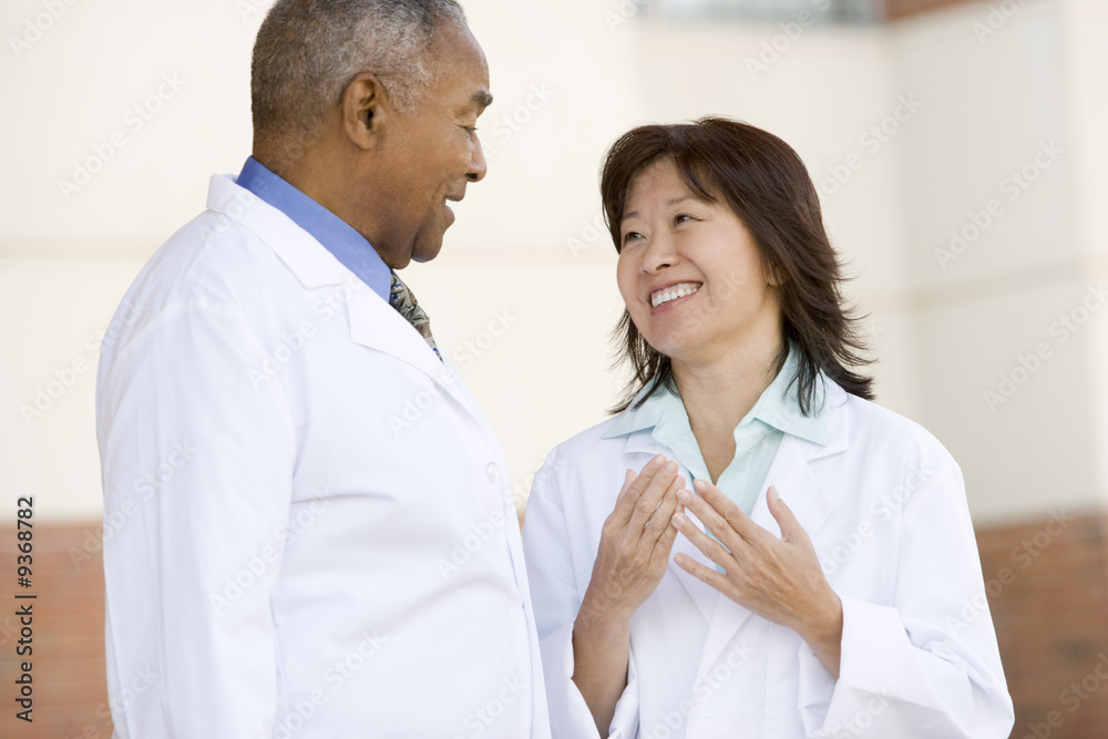 Obraz premium Two Doctors Standing Outside A Hospital