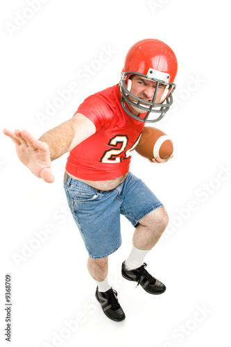Middle aged man in his high school football jersey & helmet