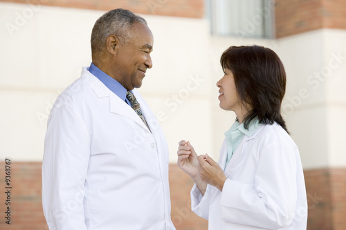 Two Doctors Standing Outside A Hospital