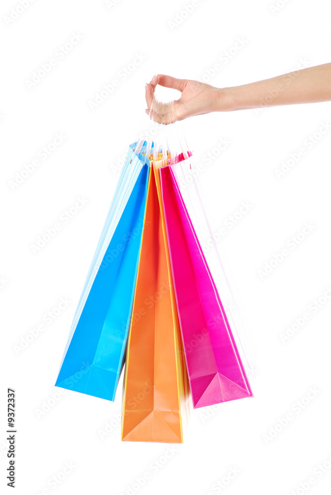 Female hand holding bright colored shopping bags