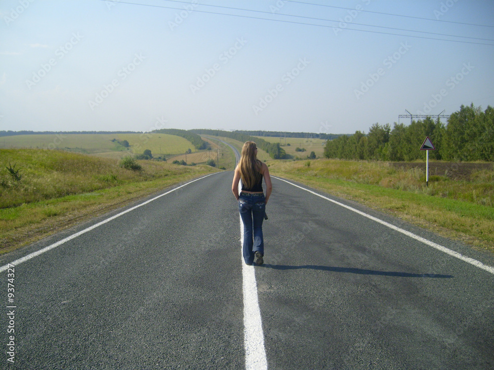 Fototapeta premium girl going far on road on background blue sky....