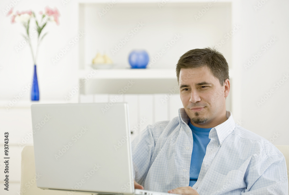 Fototapeta premium casual man teleworking using laptop computer at home.