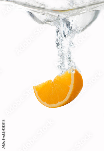 Fototapeta Naklejka Na Ścianę i Meble -  Orangenschnit fällt spritzend ins Wasser