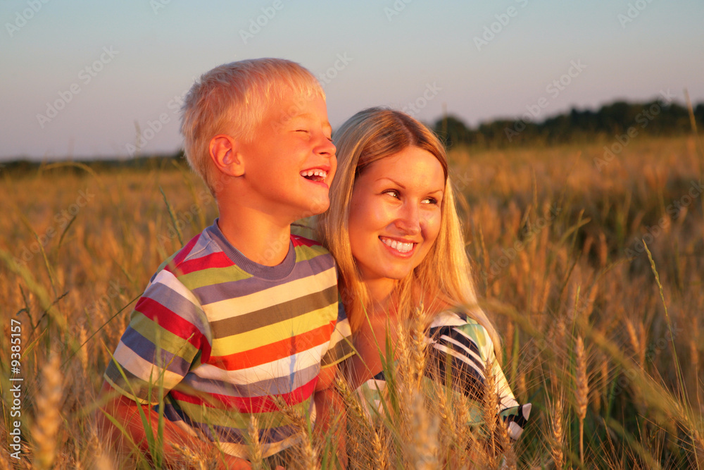 Mother and son sit on wheaten field Mother and son sit on wheaten field