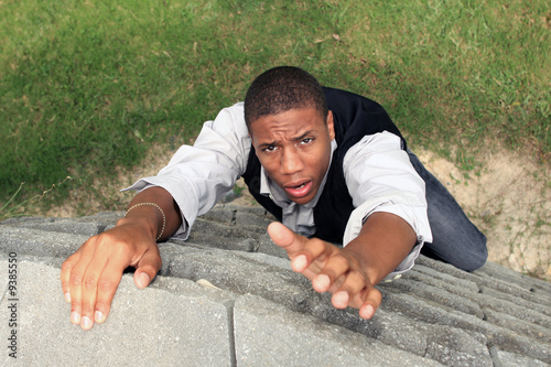 Man reaching for help while climbing a wall