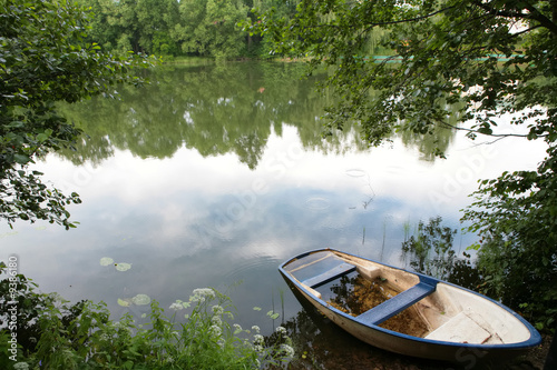 evening landscape with boat on the coast on the calm lake