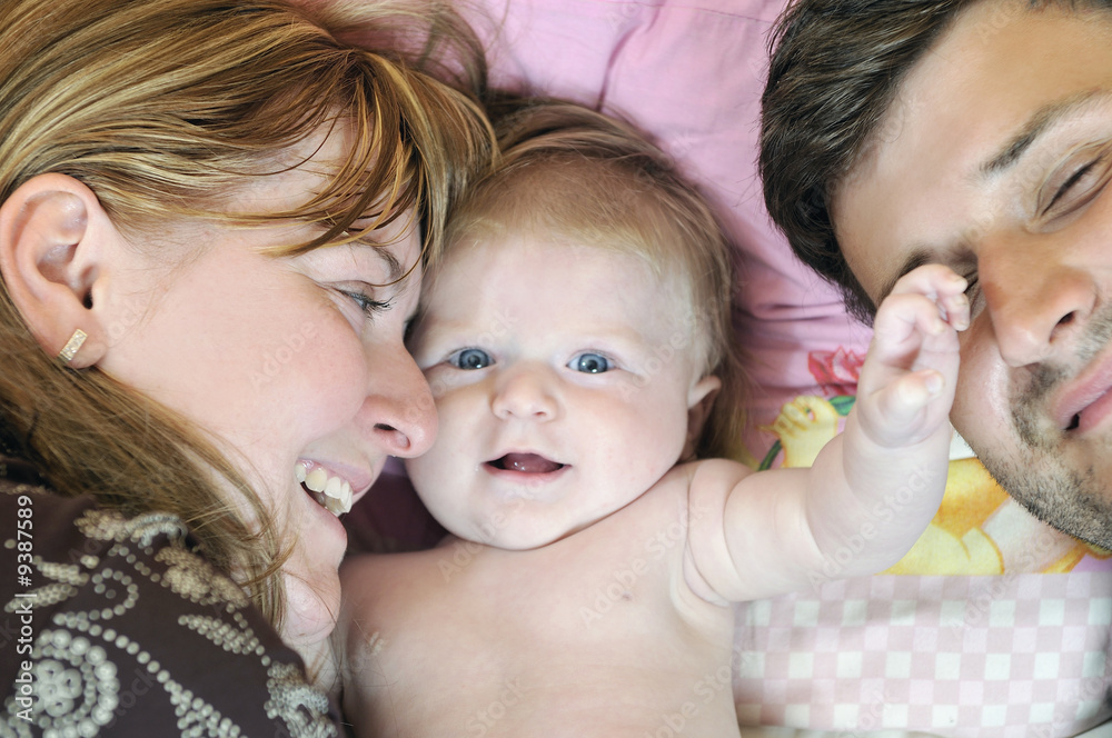 indoor portrait with happy young family and  cute little babby