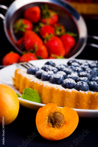 different berries and fruits with a berry cake