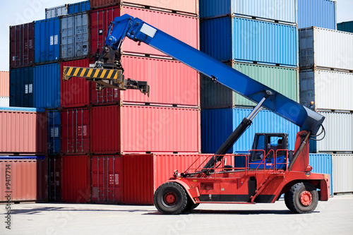 containers stacked in port with container handler / forklift