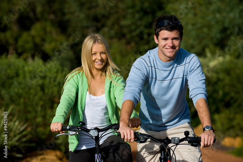 A young couple on bicycles in the countryside